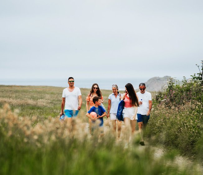 A family enjoying a peaceful stroll to the Cornish coastline on a summers day.