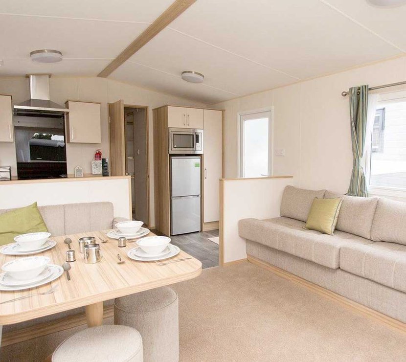 The living and dining area of our bright and spacious comfort static caravan. The perfect way to stay.