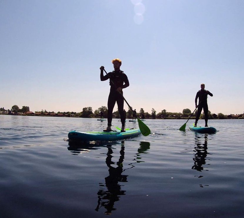 A photo of two people paddle boarding in the calm lake at our Tattershall Lakes holiday park.