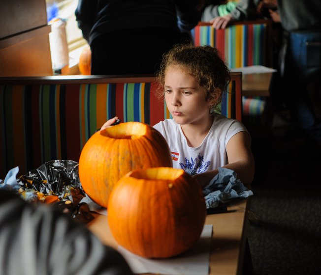 A young girl carving pumpkins at our holiday park.