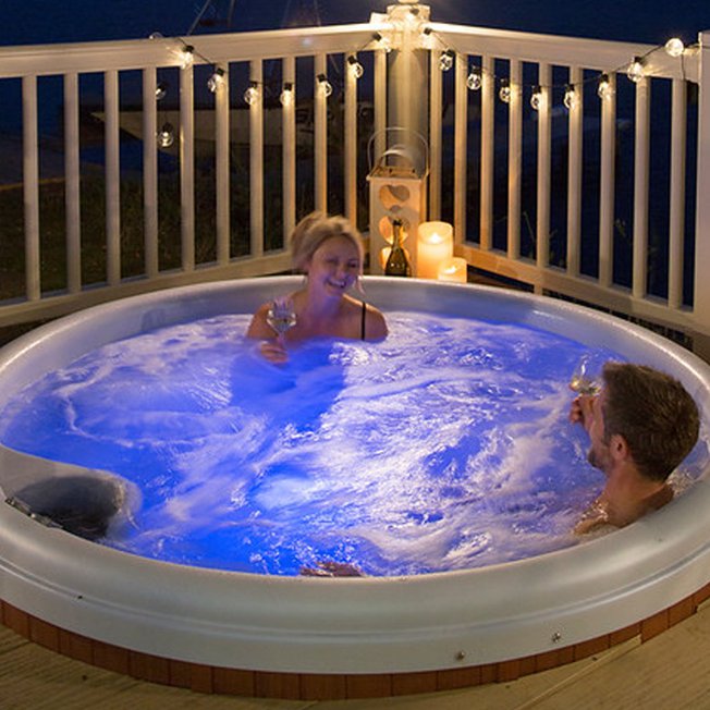 
                A couple relaxing in the hot tub together.
                