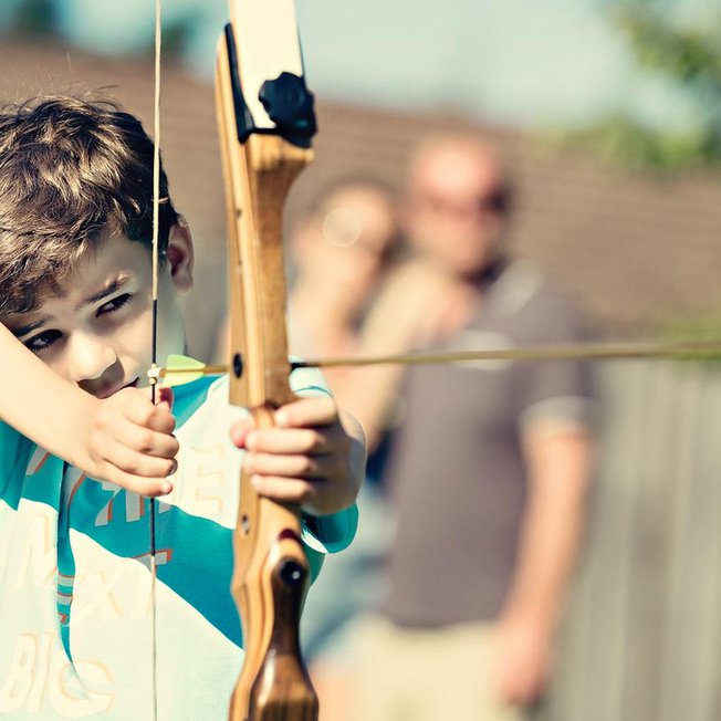 
                A young boy participating in our archery activity at one of our holiday parks.
                