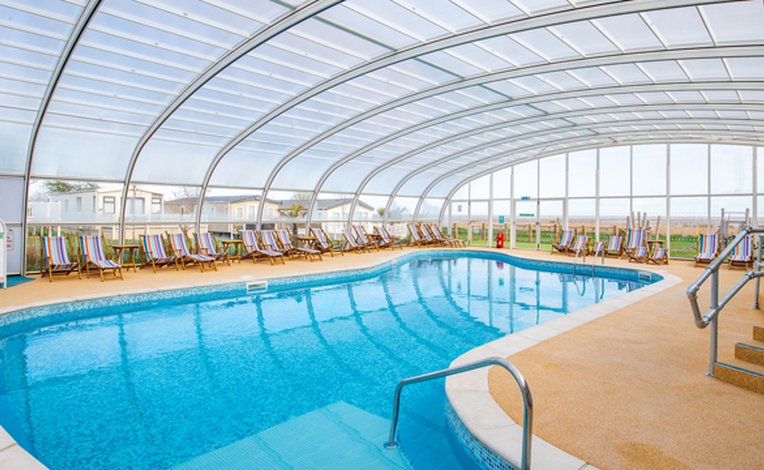 One of our spacious indoor swimming pools with a glass archway roof. Located at our holiday park in Mersea Island, Essex.