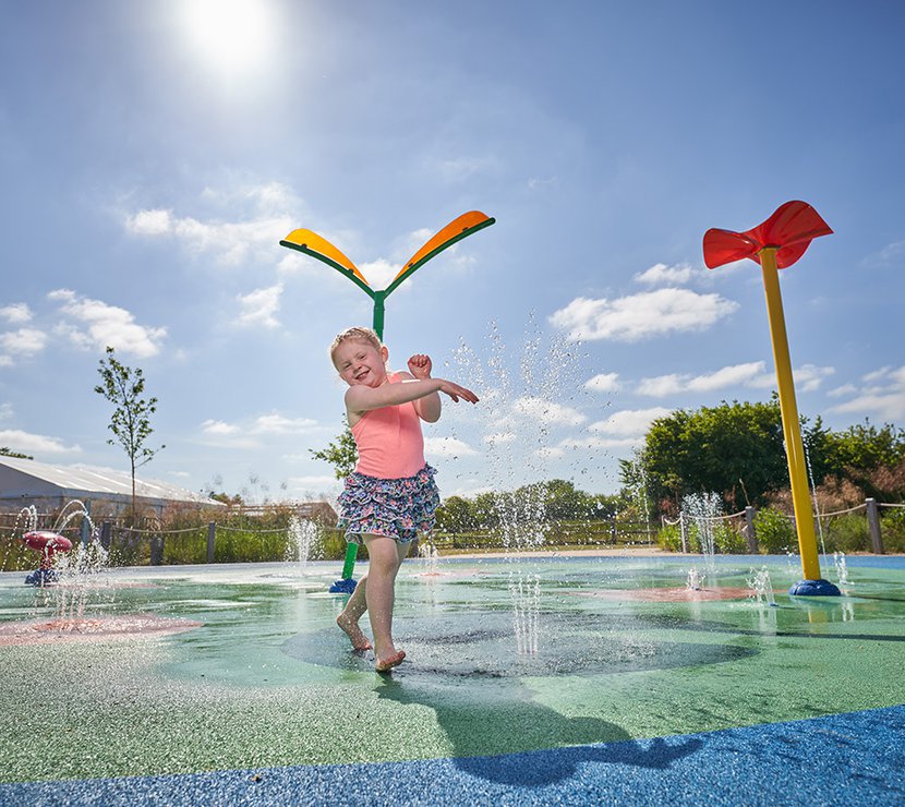 Children playing in our awesome outdoor splash pad at Appletree Holiday Park, Lincolnshire, on a sunny day.