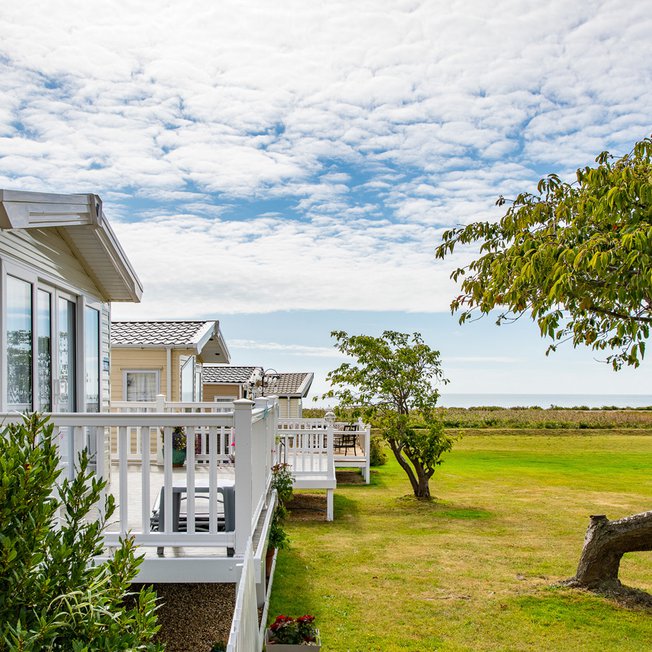 
                A row of static caravans with views of the sea at our stunning park in Essex, Mersea Island.
                