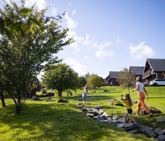 A woman and two young girls exploring the grounds of our holiday park. The are excitedly walking up a stone path.
