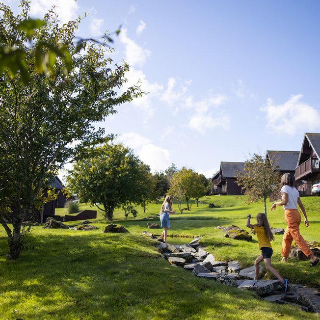 
                A woman and two young girls exploring the grounds of our holiday park. The are excitedly walking up a stone path.
                