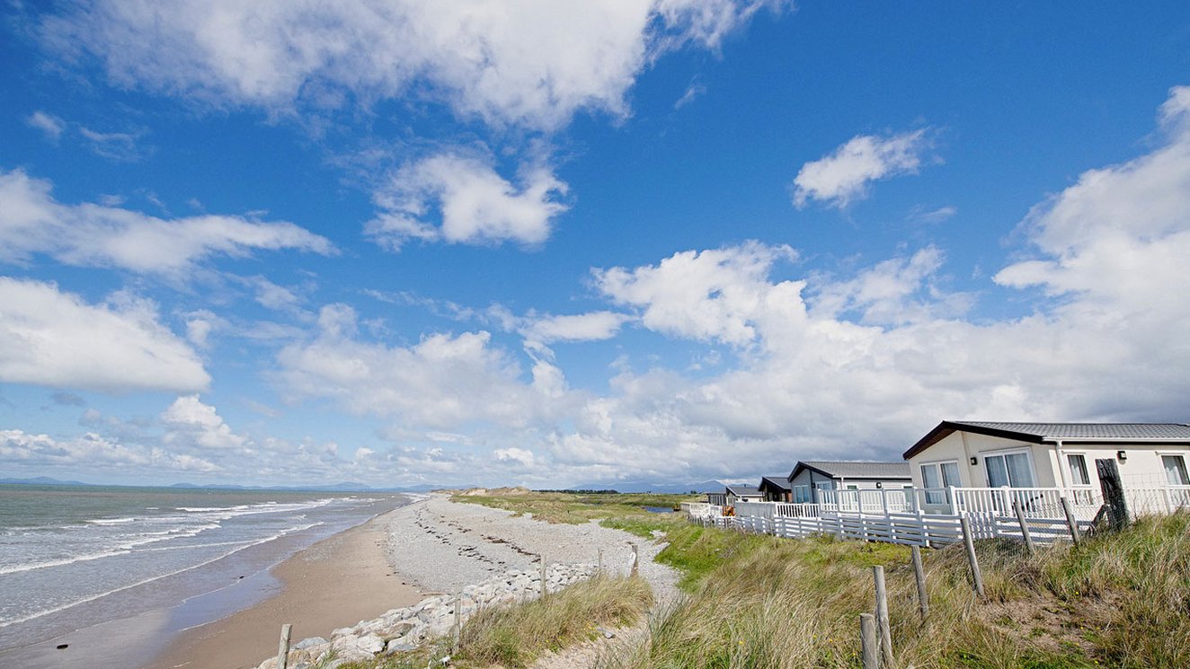 
              A sunny, cloudy day overlooking the beach at Barmouth Bay, North Wales. Book now to stay in one of our luxury static caravans.
              