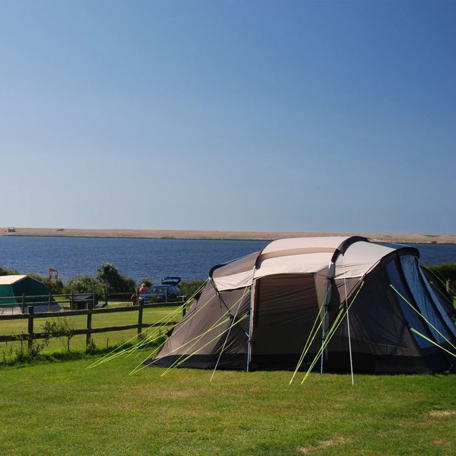 
                A pitched tent on a bright and sunny day at our East Fleet Farm holiday park in Dorset.
                