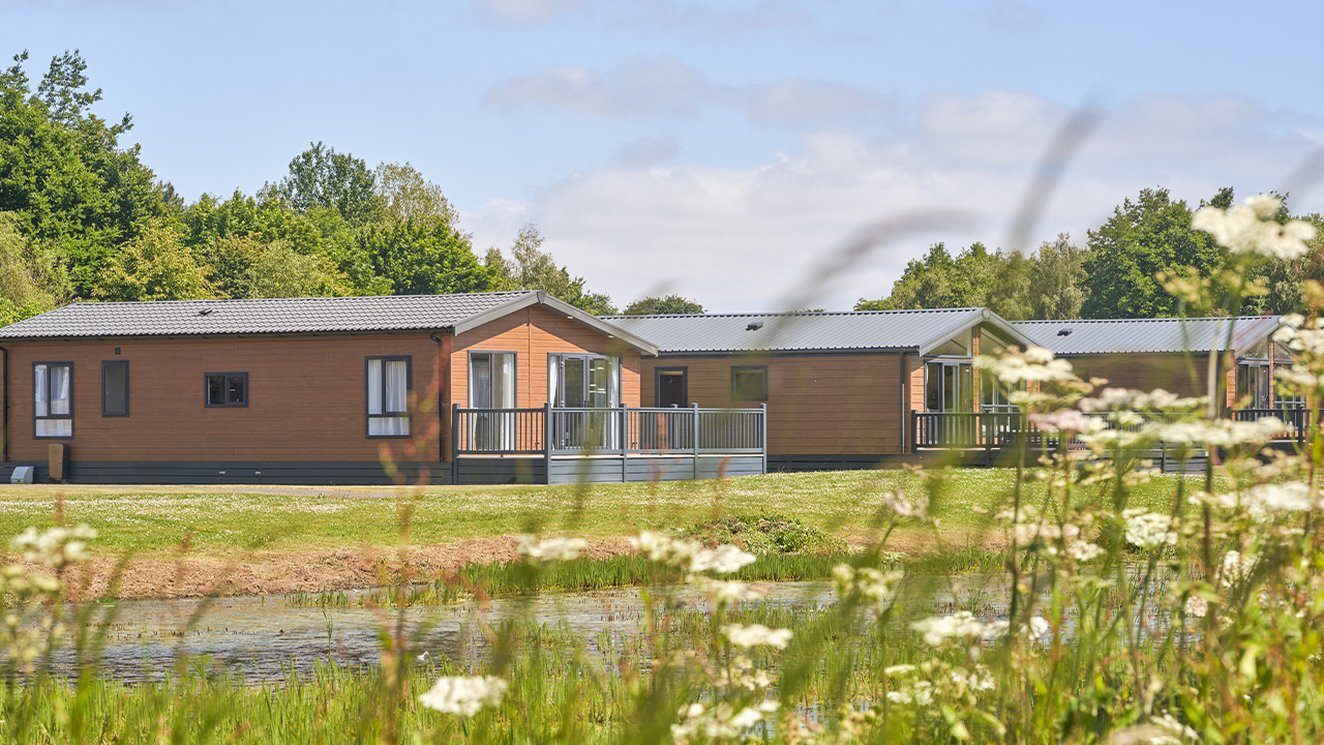 
              Over lake view of our lodges available to holiday at, Appletree Holiday Park.
              