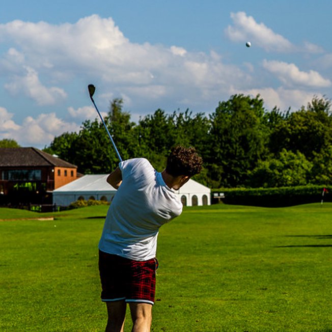 
                A man swinging his golf club while playing at our Appletree Holiday Park in Lincolnshire.
                