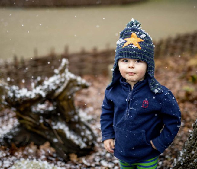 A young boy playing in the snow during the festive period.