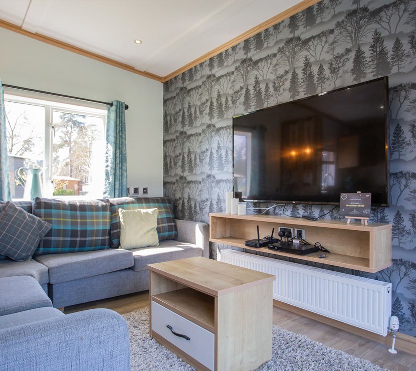 The living room space in The Zen holiday home. This holiday home has comfortable seating and a large TV. It’s designed for a restorative, calm stay.