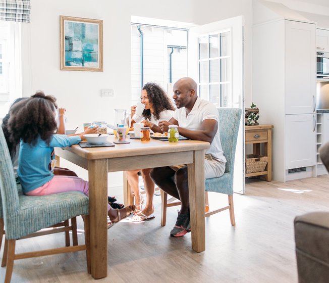 A family enjoying a meal together at the table in one of our stunning holiday homes.