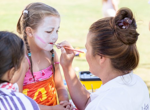 A child getting their face painted.