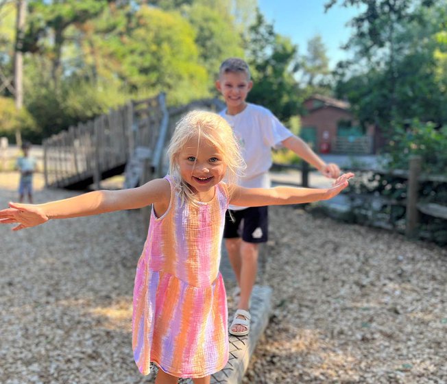 Two children playing at our woodland themed adventure playground.