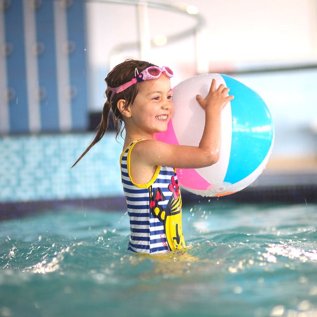 
              A young girl playing in a indoor pool at our caravan holiday park Golden Sands, North Wales.
              