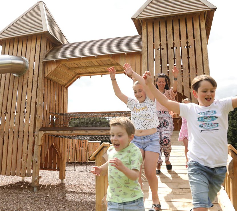 A group of children playing on a wooden climbing frame at Wyvernwood.