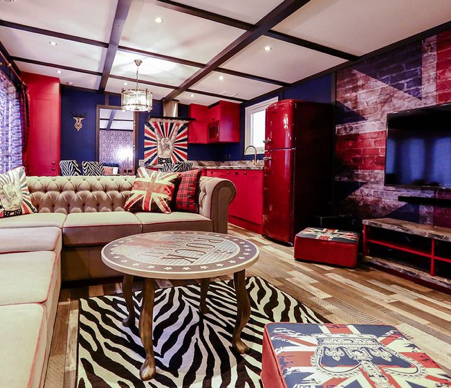 The lounge in our Rockstar holiday home. There’s a spacious kitchen, a large TV and sofa, and a theme of red, white, and blue Great British colours.