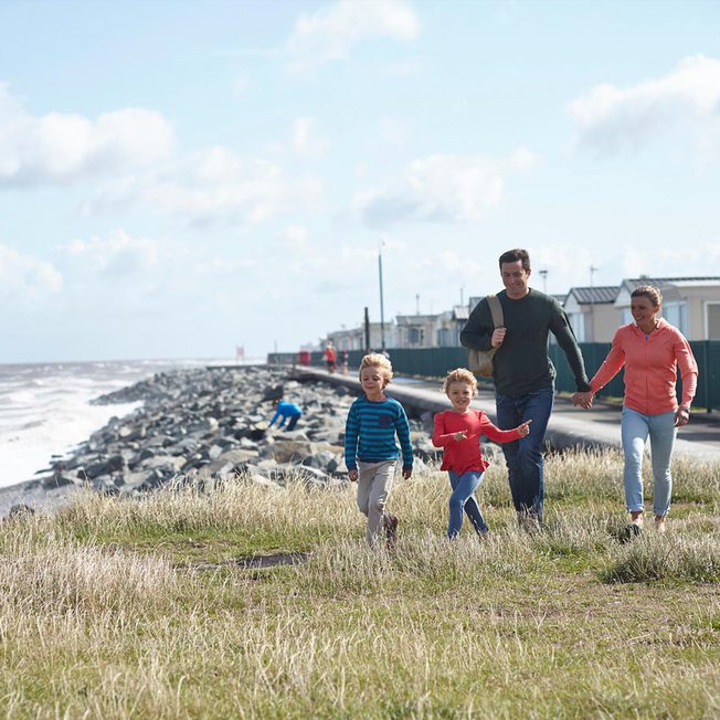 
                A family walking in our Golden Sands holiday park.
                