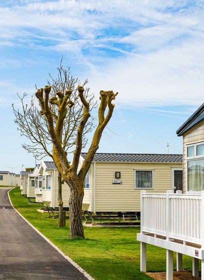 A row of caravans at our park in Essex, Mersea Island on a sunny, cloudy day.