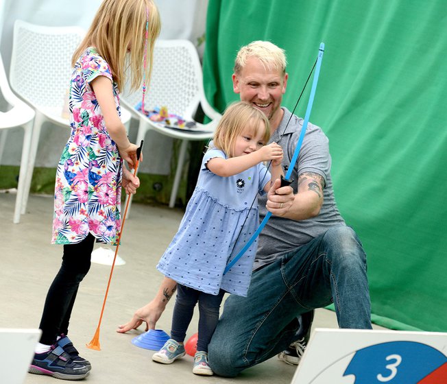 A family taking part in the Mini Archery activity.