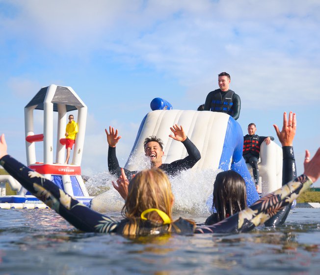 A group of adults enjoying their day at the Aqua Park at our stunning Cornish resort, Retallack Resort & Spa.