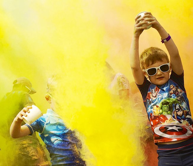 A colour festival event at one of our holiday parks. The young children are splashing colourful substances into the air at our incredible event.