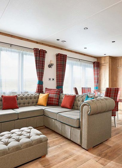 The Heartwood holiday home lounge area. This space has a large sofa, a dining area, and décor that reflects Scottish baronial living.