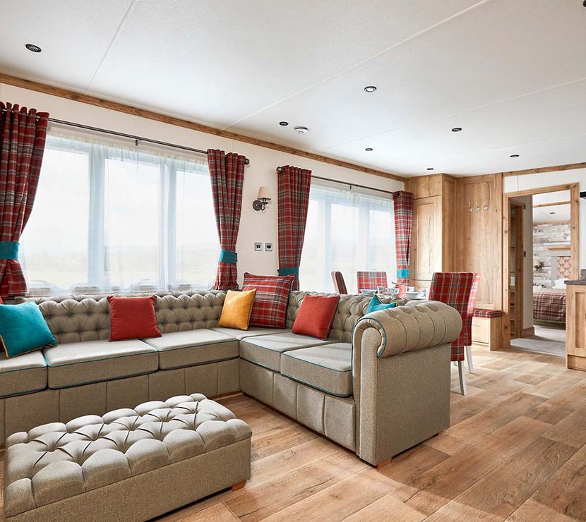 The Heartwood holiday home lounge area. This space has a large sofa, a dining area, and décor that reflects Scottish baronial living.