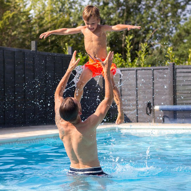 
                A dad and child playing in our outdoor pool.
                